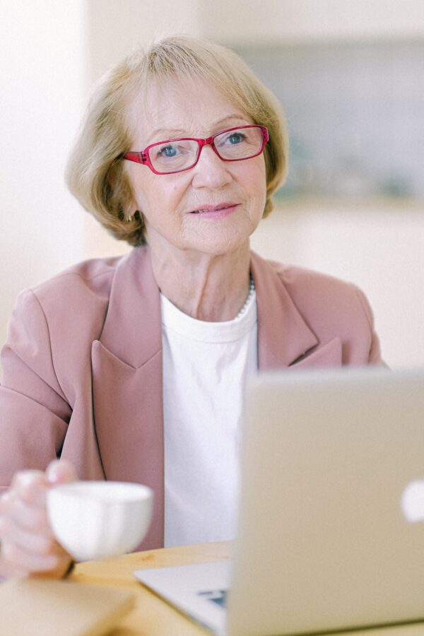 A woman sitting at a table with a laptop.